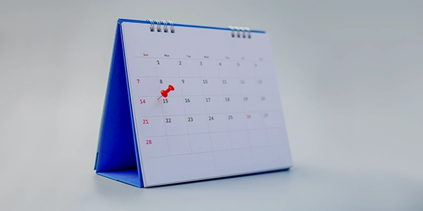 A desk calendar with a red office pin.